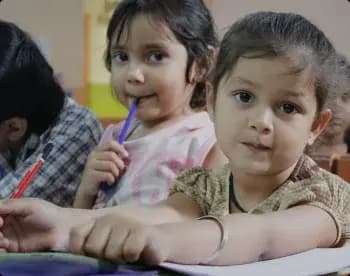 Young children writing in their notebooks during a Ramagya Foundation class